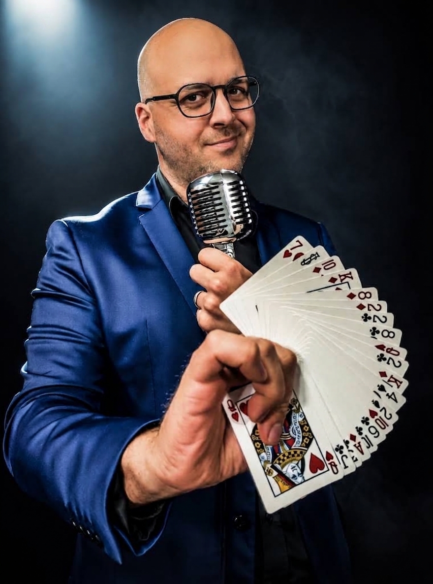 Michael Bourada with a deck of playing cards and microphone